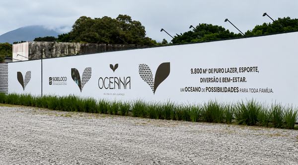 Tapume de obra do Oceana, com grafismo da marca