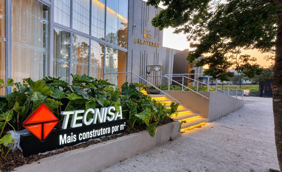 Letra caixa da Tecnisa na entrada do stand, ao entardecer