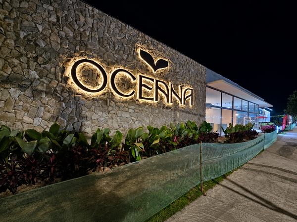 Letra caixa iluminada do Oceana em muro de pedra, à noite